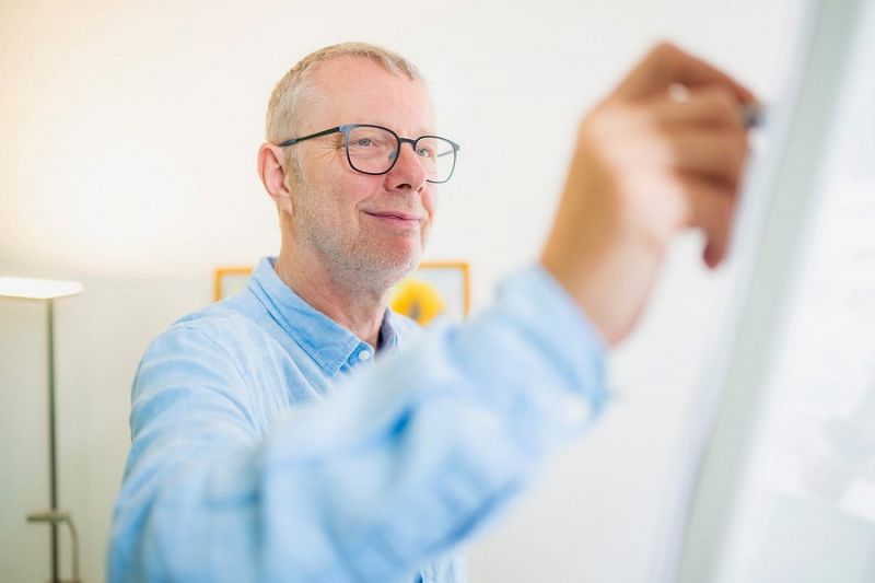 Johannes Vennen schreibt etwas auf eine Whiteboard-Tafel